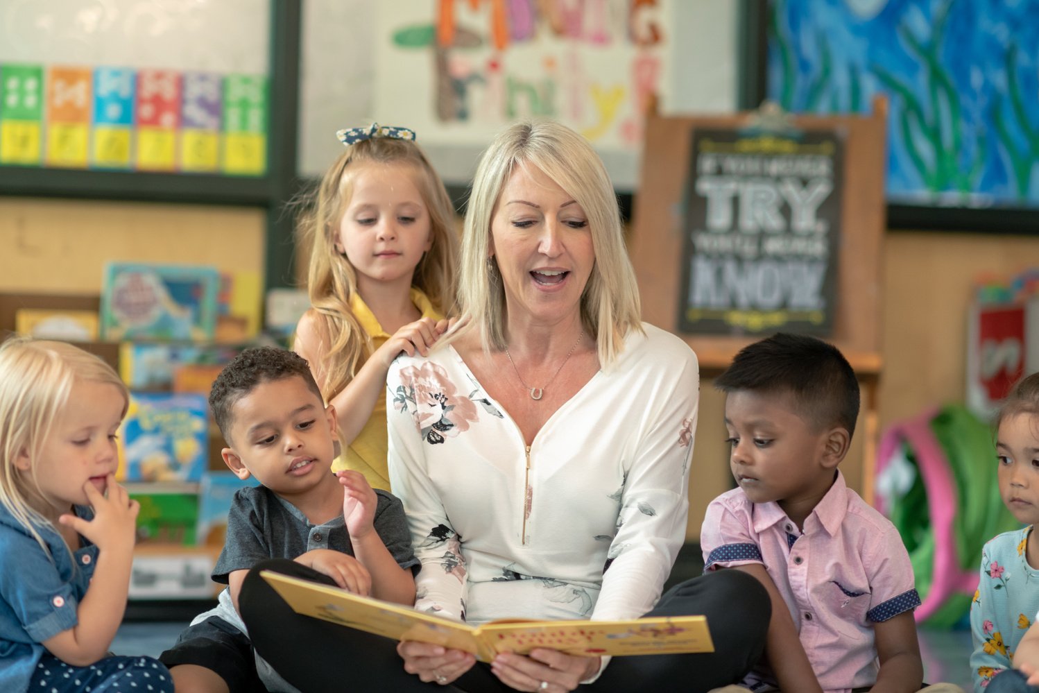 Preschool teacher reading with students